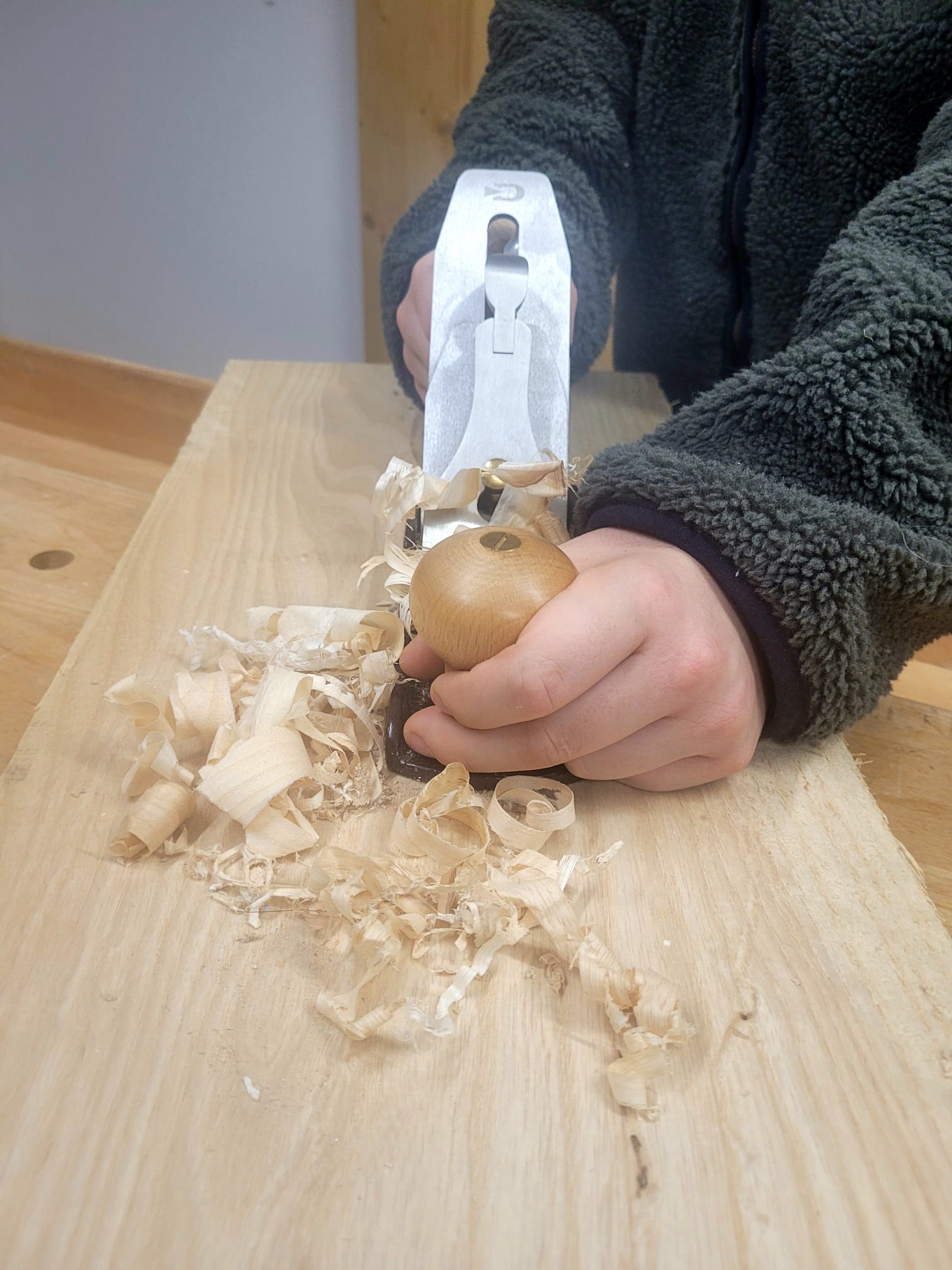Person working with woodworking tools on a piece of wood